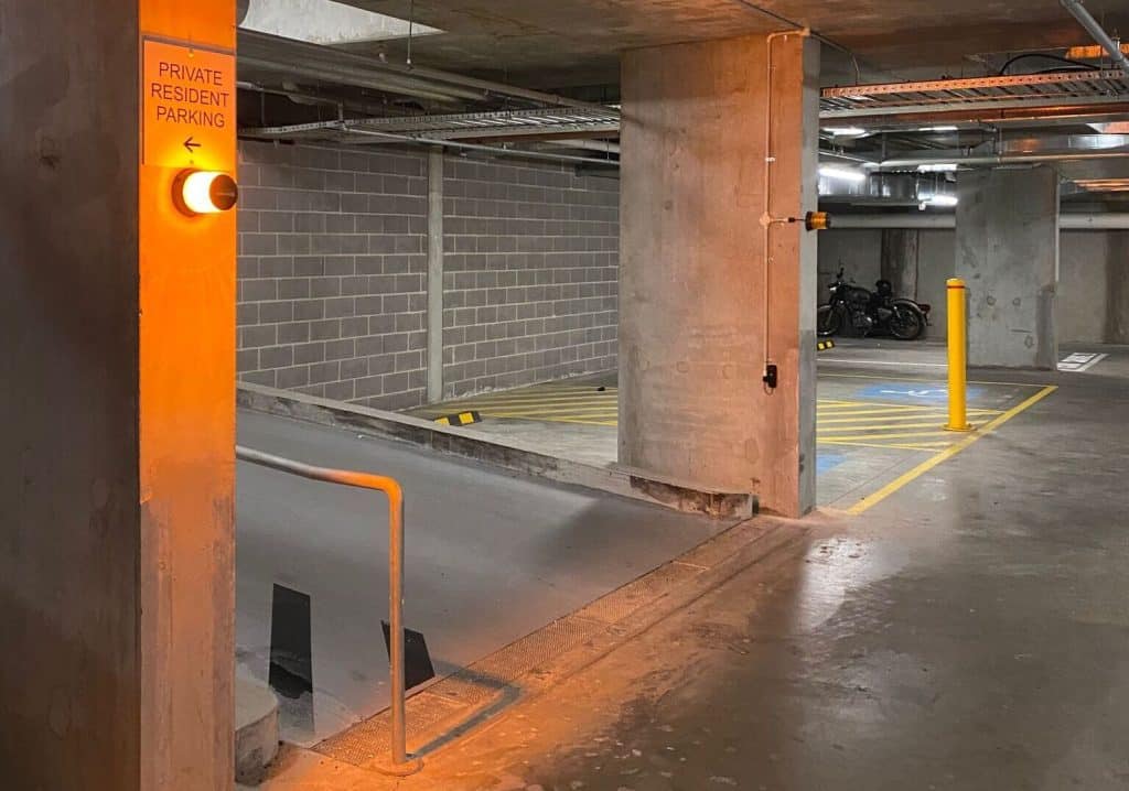 A vehicle detection system installed in a private resident parking garage, featuring an illuminated traffic light and clear signage for vehicle access control.